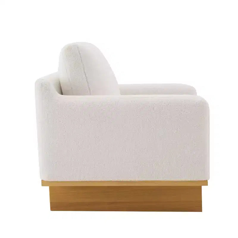 Poltrona moderna Niran in legno di gomma con rivestimento in bouclé e morbido cuscino