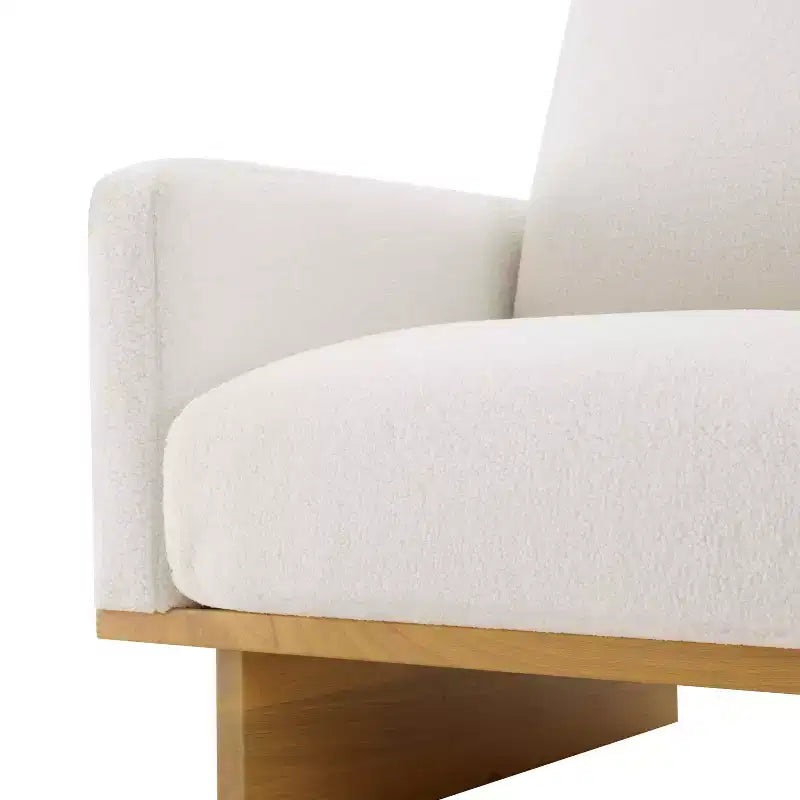 Poltrona moderna Niran in legno di gomma con rivestimento in bouclé e morbido cuscino
